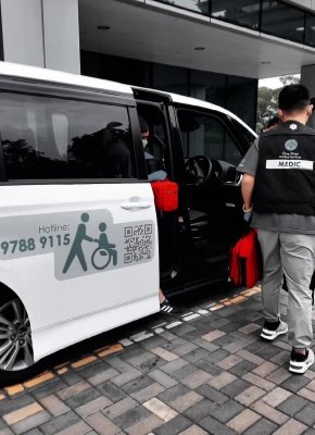 工作人員協助行動不便者安全登上一站醫護通接送車，車身印有清晰無障礙標誌