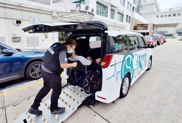 工作人員協助行動不便者安全登上一站醫護通接送車，車身印有清晰無障礙標誌
